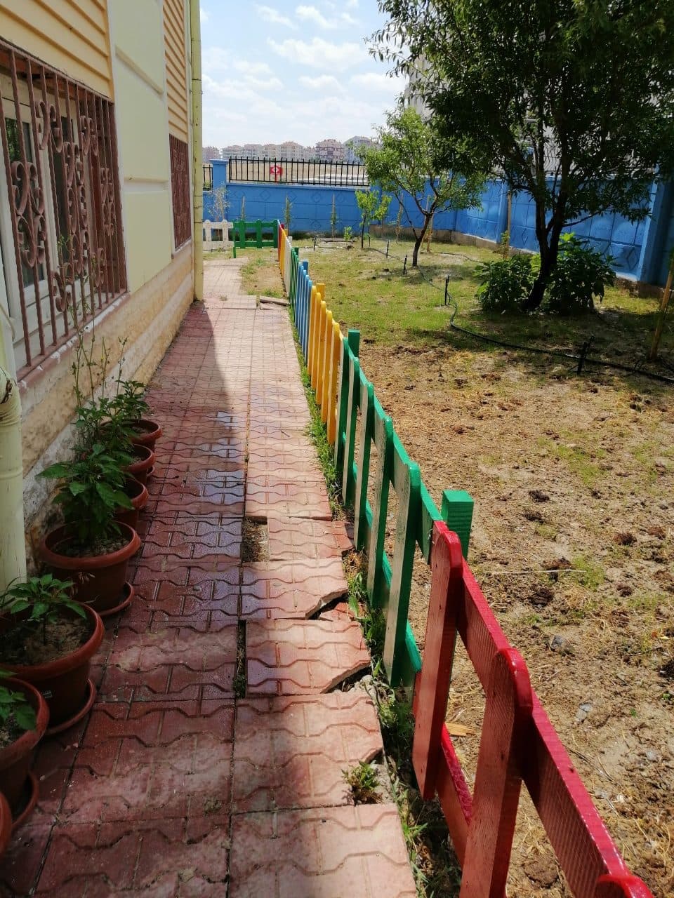 Renkli çitlerle çevrili bahçe yolu