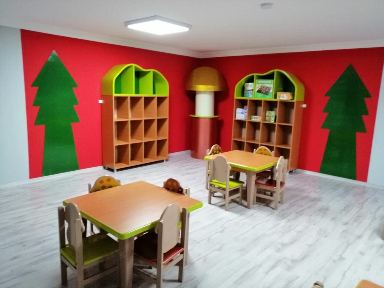 Ağaç figürleri ve renkli raflarla orman temalı sınıf